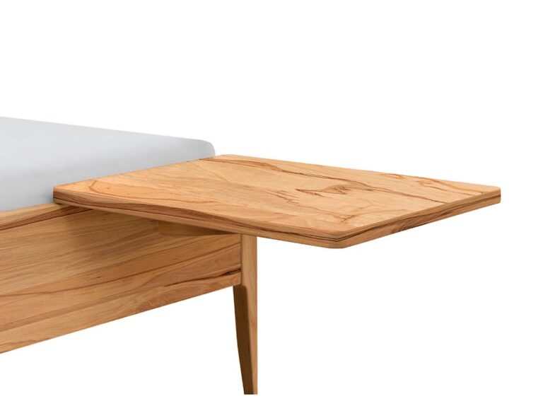 Eine Nahaufnahme eines Holzpritschenbettes mit einem eingebauten, schwebenden Nachttisch, der am Rahmen befestigt ist. Das Bett ist aus hellem Holz und hat ein glattes, minimalistisches Design.