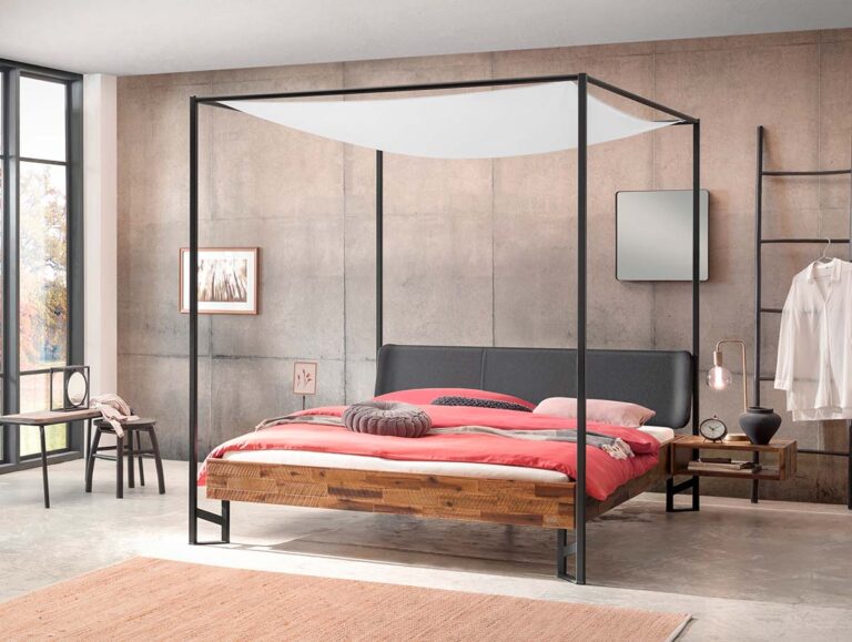 Ein modernes Schlafzimmer mit einem Himmelbett, korallenrotem Bettzeug, einem runden rosa Kissen und einem hölzernen Nachttisch. Das Zimmer hat Betonwände, große Fenster, eine minimalistische Einrichtung und ein Hemd, das an einem Wandständer hängt.