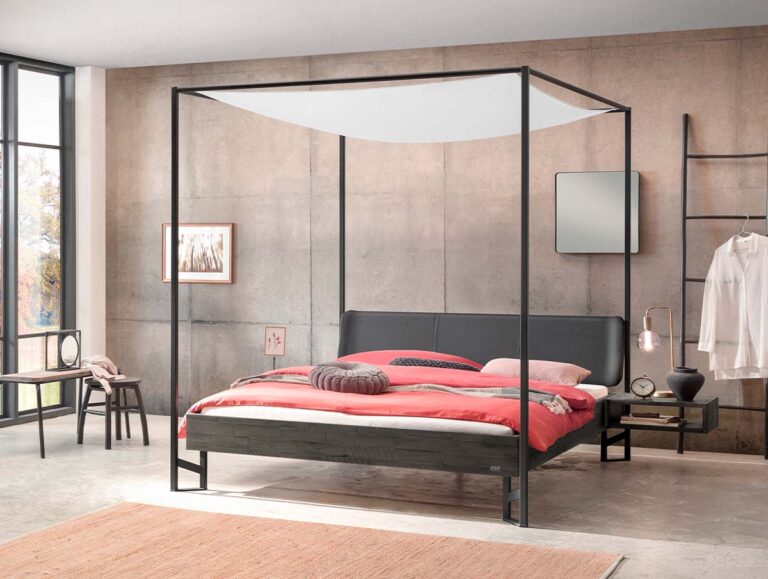 Modernes Schlafzimmer mit einem schwarzen Himmelbett, korallenroter Bettwäsche und minimalistischem Dekor. Das Zimmer verfügt über Betonwände, große Fenster, einen Spiegel, Wandkunst und einfache Möbel wie einen Stuhl und einen Nachttisch.
