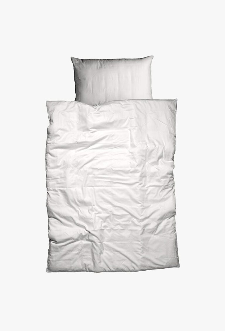 Bettwäsche Nobilium Oni zeigt ein ordentlich gemachtes Bett mit einem weißen Kissen und einer leicht zerknitterten weißen Bettdecke, von oben gesehen vor einem schlichten weißen Hintergrund.
