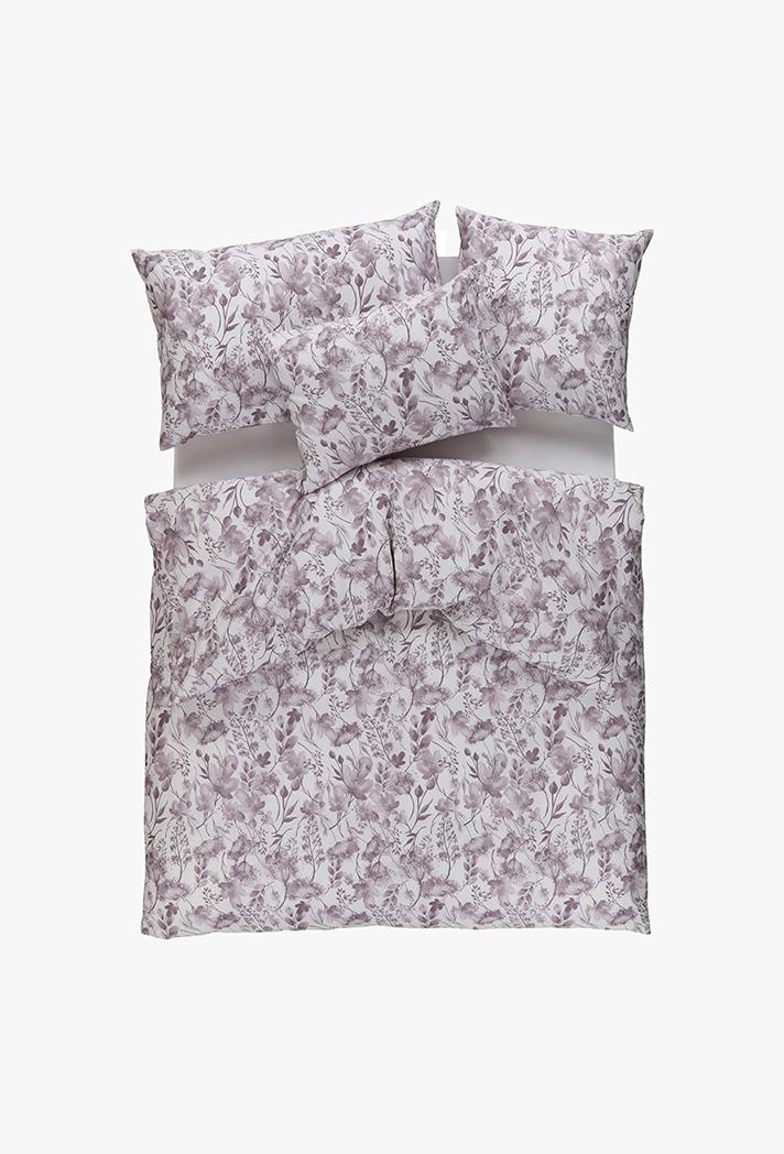 Das Bettwäsche-Set Jil lila mit einem hellvioletten Blumenmuster auf weißem Grund wird auf einem ordentlich gemachten Bett mit zwei Kissen und einer Bettdecke gezeigt, alles vor einem schlichten weißen Hintergrund.