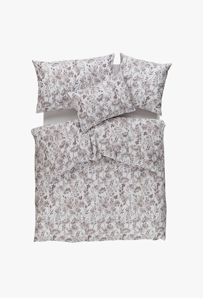 Auf einem ordentlich gemachten Bett liegt Bettwäsche Jil beige - ein floral gemusterter Bettbezug mit Kissenbezügen in hellen Beige- und Brauntönen - von oben auf einem weißen Hintergrund.