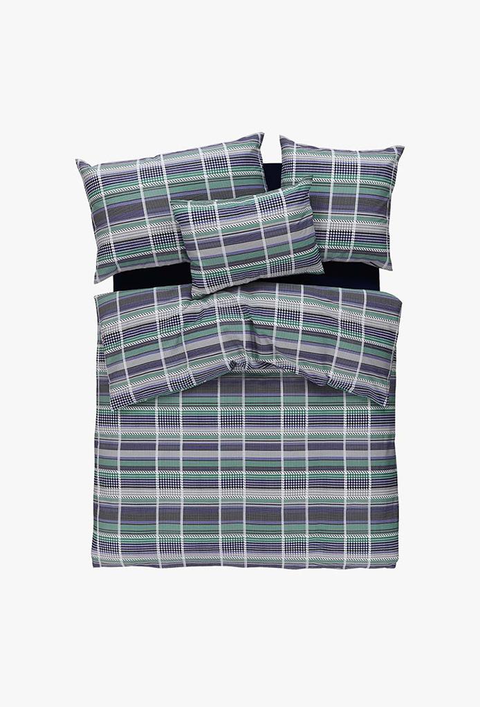 Ein hübsch gemachtes Bett mit Bettwäsche Movi, blau-weiß-grün kariert auf strahlendem Weiß - inklusive zwei Kissen, zwei Unterbetten und einer Bettdecke.