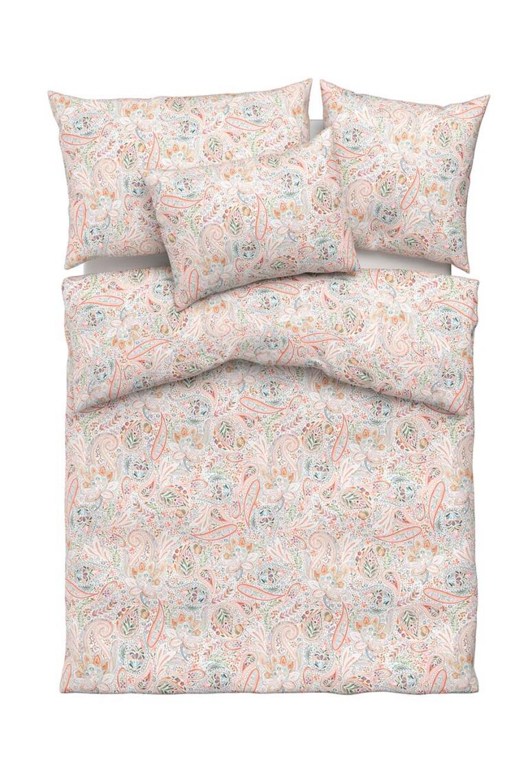 Ein Bett mit einem Bettbezug und drei Kissen, die alle mit einem pastellfarbenen Paisleymuster in sanften Rosa-, Orange-, Blau- und Grüntönen auf weißem Hintergrund versehen sind.