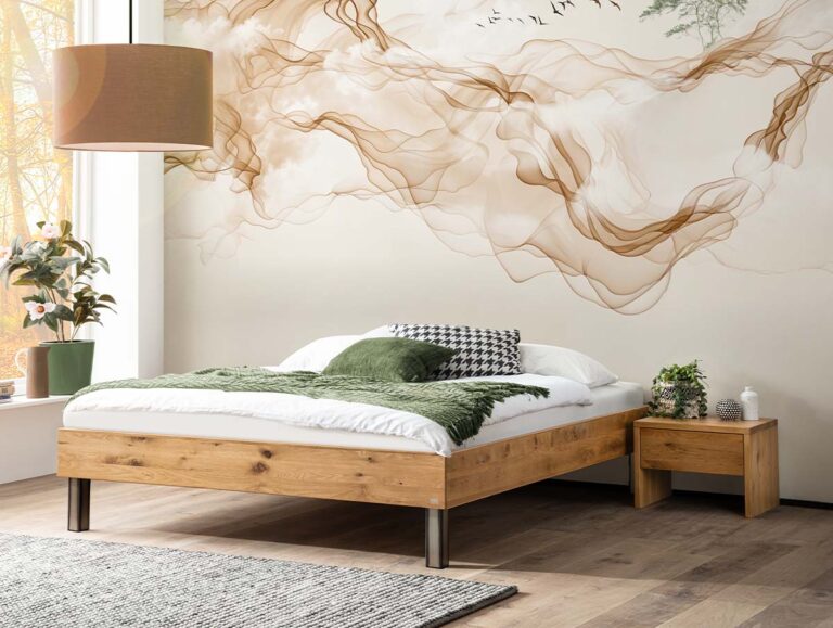Ein Bettgestell aus Holz mit grüner Bettwäsche und gemusterten Kissen vor einer Wand, die mit einem dekorativen Wandbild verziert ist, auf dem brauner Rauch wirbelt und Vögel fliegen.
