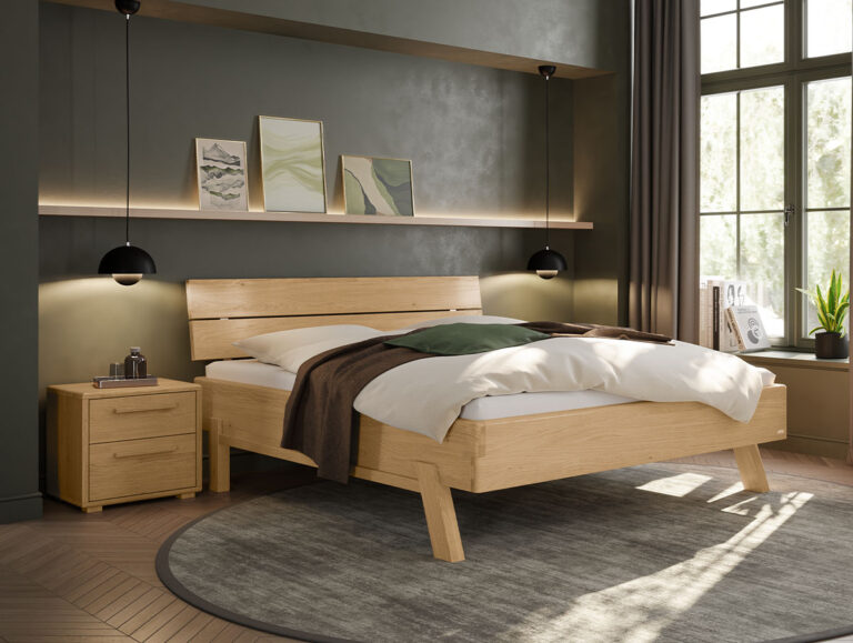 Modernes Schlafzimmer mit einem Holzbett, weißer Bettwäsche, einer grünen Decke, zwei schwarzen Pendelleuchten, einem Nachttisch, Kunstwerken auf einem Regal und großen Fenstern, durch die Tageslicht hereinströmt. Runder Teppich auf Holzboden.