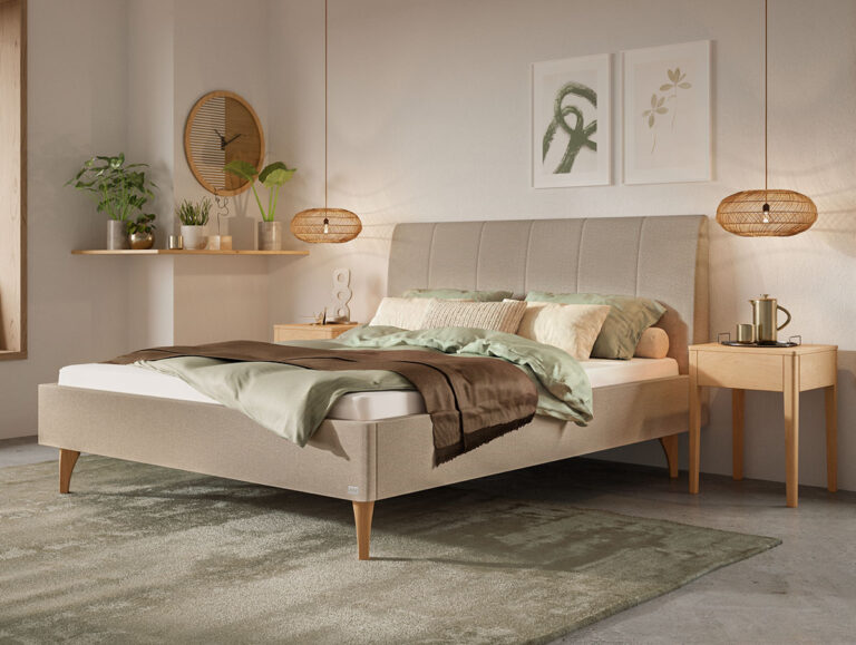 Ein modernes Schlafzimmer mit einem beigen Polsterbett, grüner und brauner Bettwäsche, Nachttischen aus Holz, hängenden Korb-Lampen, Topfpflanzen, einem runden Spiegel und botanischen Kunstdrucken an der Wand; sanftes, natürliches Licht durchflutet den Raum.